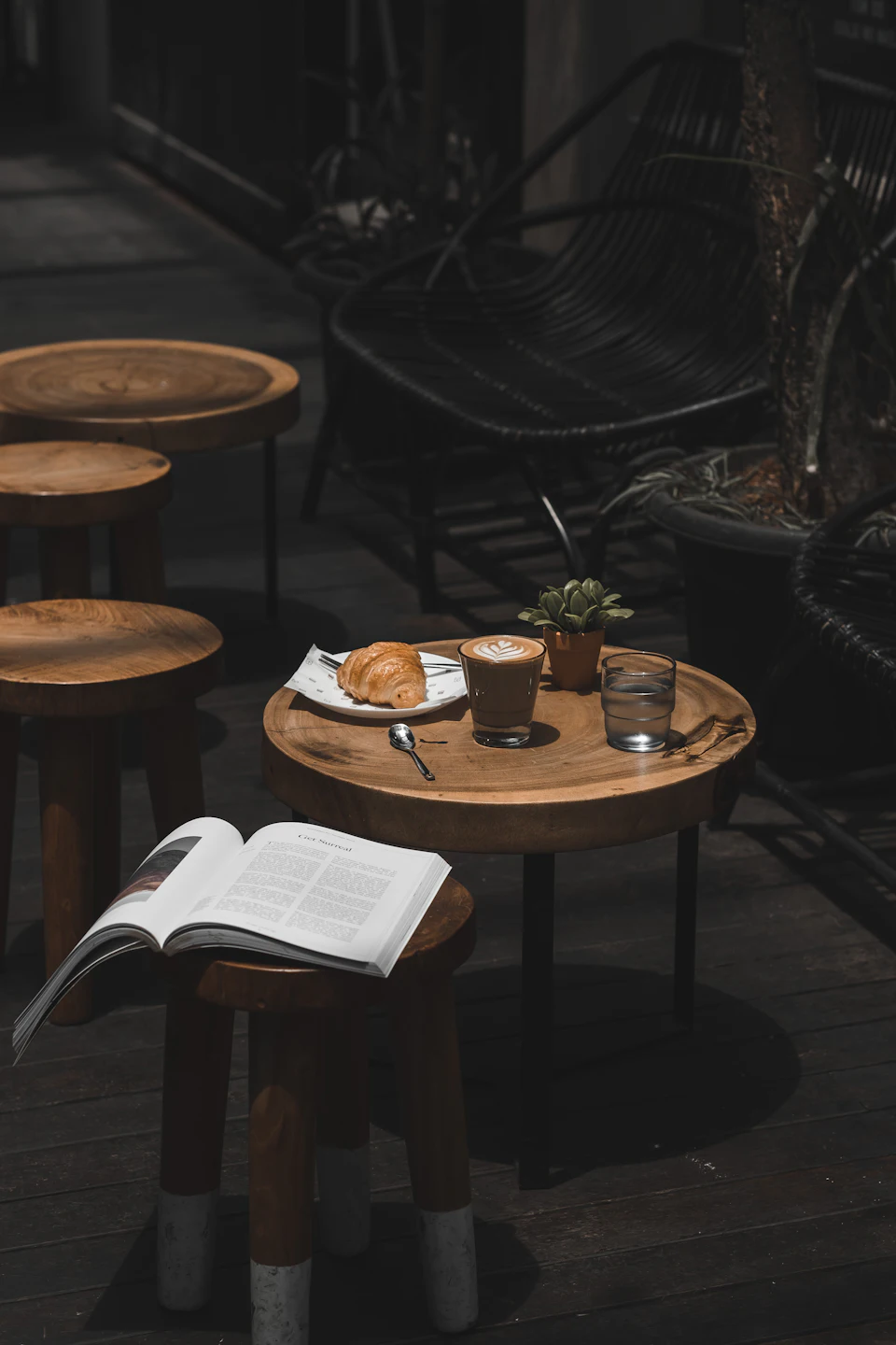 Latte croissant and book on cafe table
