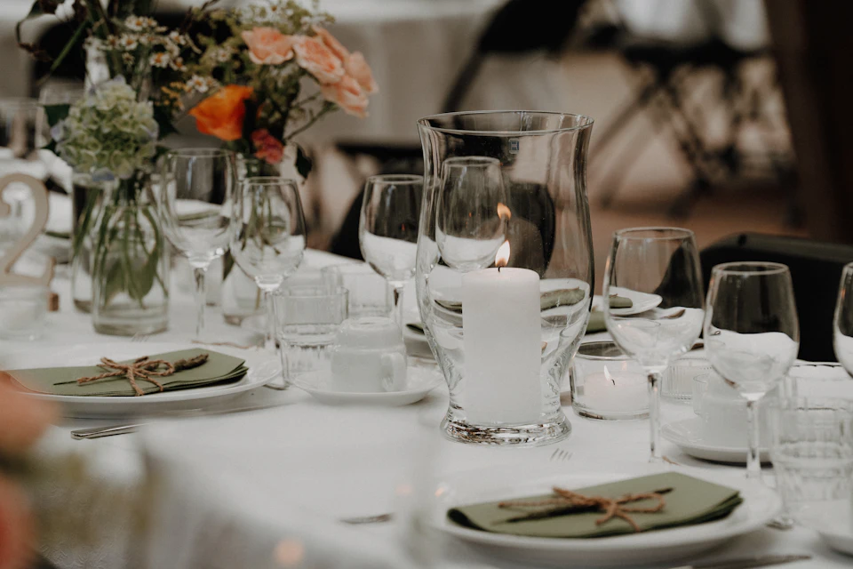 A decorated table setting with a lit candle and flowers